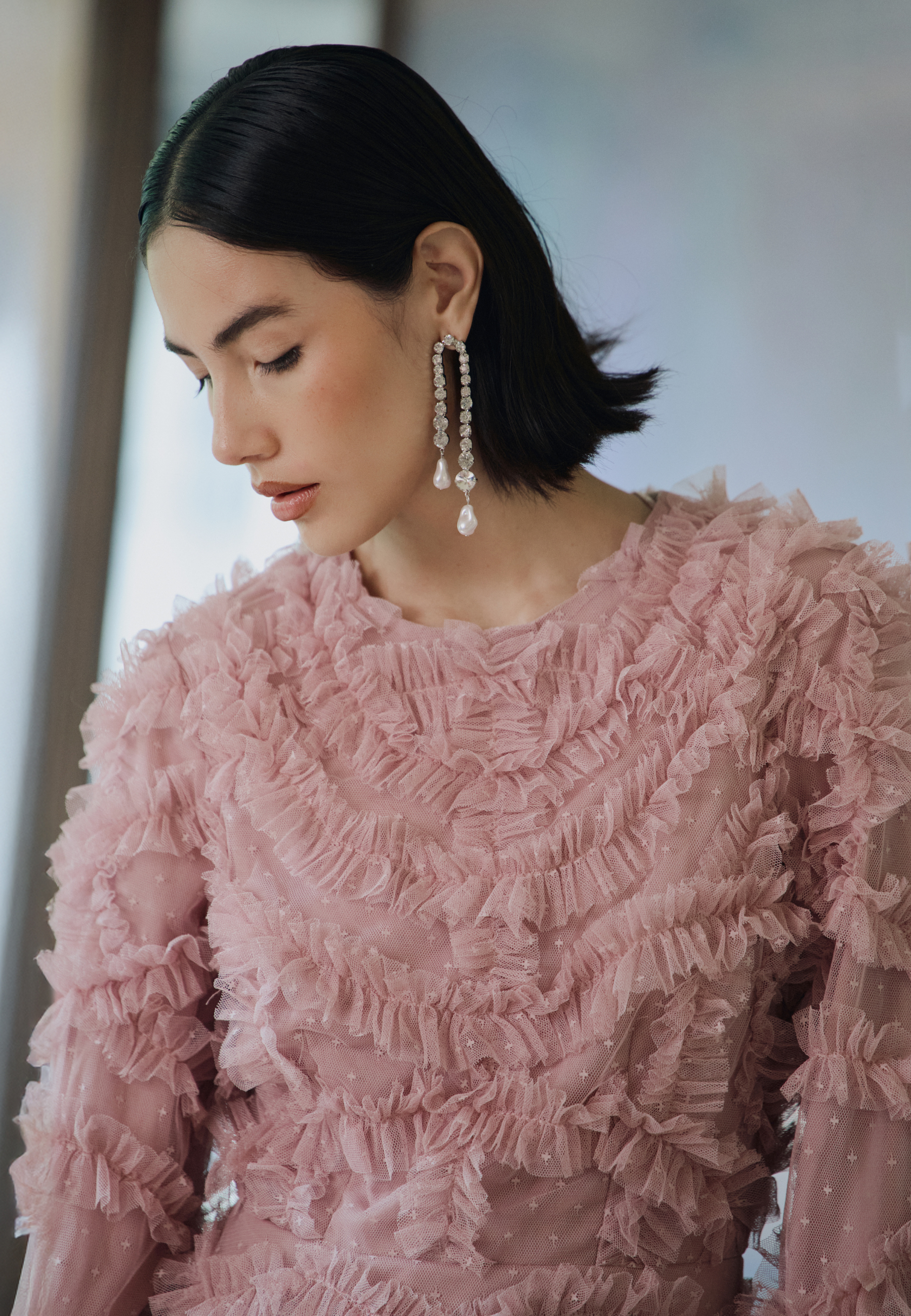 Woman wearing a pink ruffled dress with a blurred background